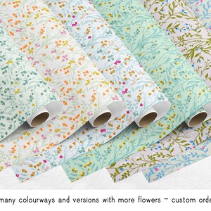 May include: A collection of floral patterned wrapping paper rolls in various colors, including blue, green, pink, and orange. The rolls are arranged in a staggered pattern, with the ends of the rolls visible. The paper features a delicate floral design with small flowers and leaves.