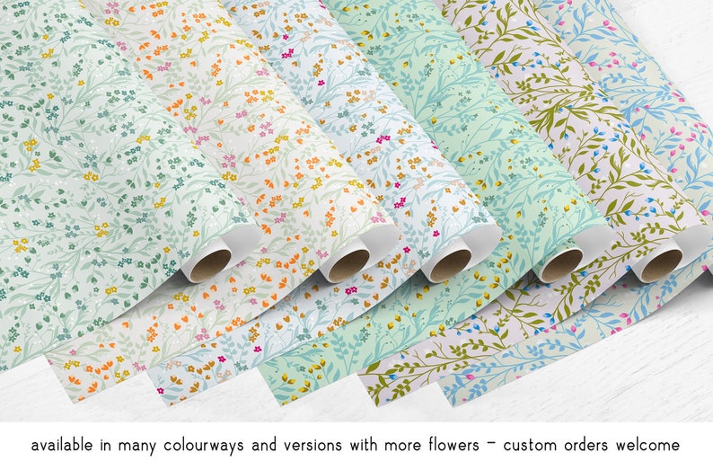 May include: A collection of floral patterned wrapping paper rolls in various colors, including blue, green, pink, and orange. The rolls are arranged in a staggered pattern, with the ends of the rolls visible. The paper features a delicate floral design with small flowers and leaves.