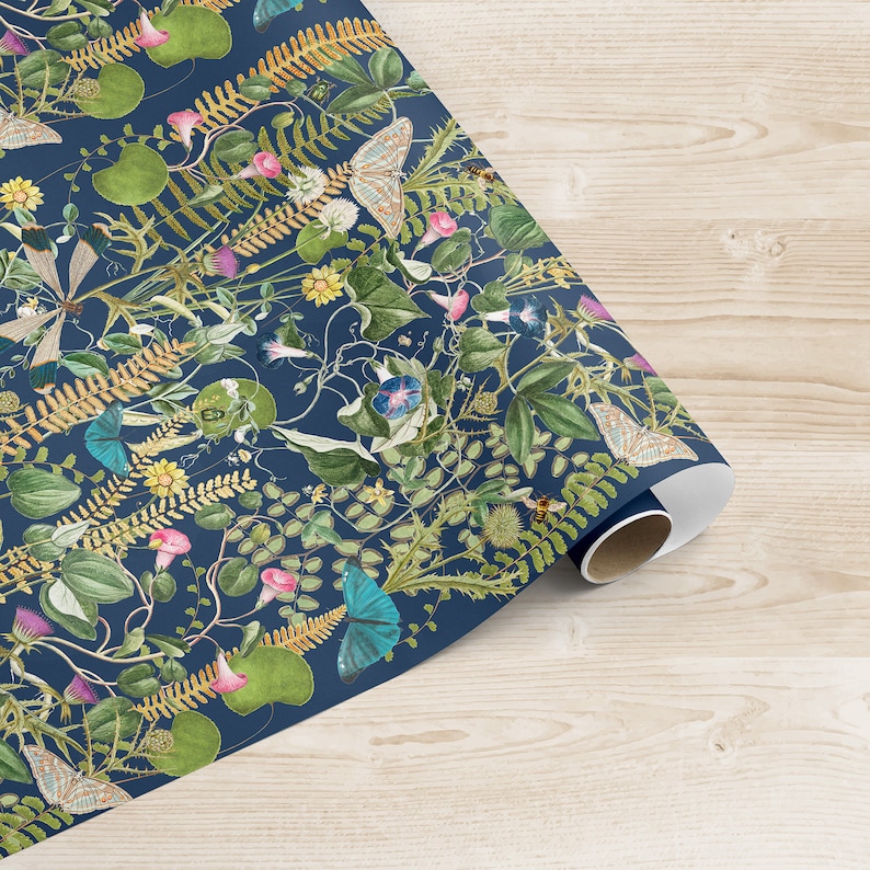 May include: Blue wrapping paper with a floral pattern featuring butterflies, bees, and ferns. The paper is rolled up and ready to be used.