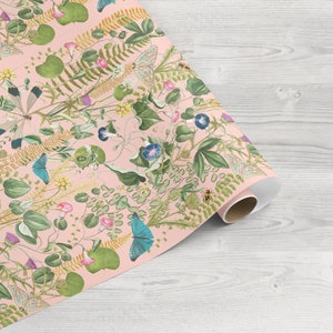 May include: Pink wrapping paper with a floral pattern featuring butterflies, bees, and leaves. The paper is rolled up and ready to be used.
