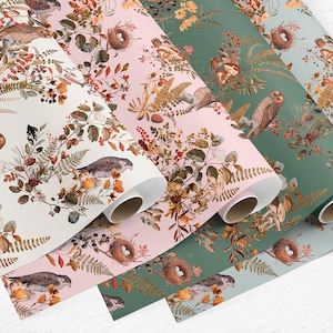 May include: Four rolls of wrapping paper with a woodland theme. The paper features a repeating pattern of owls, birds, ferns, and berries on a white, pink, green, and blue background.