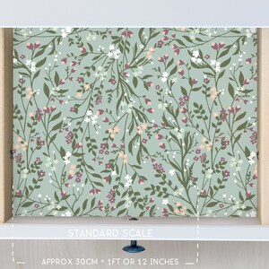 May include: A drawer liner with a floral pattern featuring small white and pink flowers on a light blue background. The liner is 1 foot or 12 inches long.