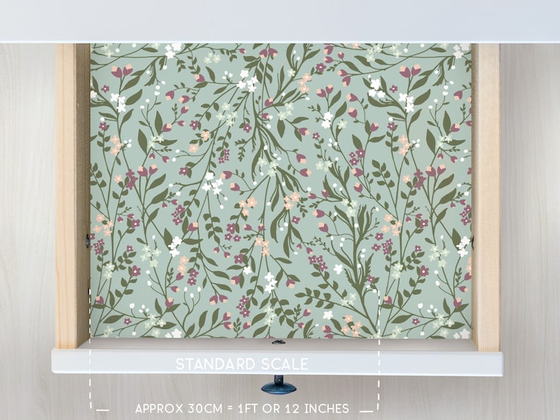 May include: A drawer liner with a floral pattern featuring small white and pink flowers on a light blue background. The liner is 1 foot or 12 inches long.