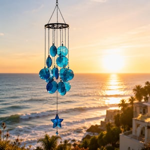 May include: A hanging wind chime featuring a circular black metal frame with multiple translucent blue glass discs suspended by thin metal chains, culminating in a single blue glass star at the bottom, all arranged in a cascading vertical design.