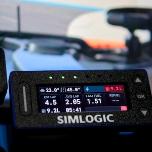 May include: A black Simlogic digital dashboard display unit featuring a rectangular screen with illuminated data metrics including 23.0 degrees, 45.0 degrees, 9.2L fuel, 4.5 est lap, 2.05 avg lap, and 1.51 last fuel, with three green status lights above.