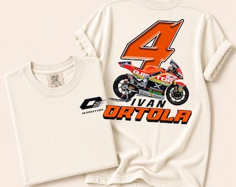May include: An off-white t-shirt featuring a small black QJMOTOR logo on the front. The back displays a large orange number 4, a racing motorcycle graphic, and the text IVAN ORTOLA in bold orange letters with a black outline and drop shadow.