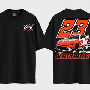 Könnte beinhalten: Schwarzes T-Shirt mit einem Rennwagendesign. Auf der Vorderseite stehen die Buchstaben "B" und "W" mit dem Namen "Wallace". Auf der Rückseite sind die Nummer "23" und der Name "Bubba Wallace" in Orange und Weiß abgebildet.