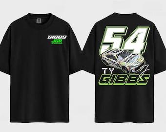 May include: A black short-sleeve t-shirt featuring a small white and green GIBBS JGR logo on the front chest. The back displays a large graphic of a race car, the number 54, and the text TY GIBBS in white and lime green lettering.