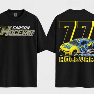 May include: Black t-shirt featuring the name "CARSON HOCEVAR" in a yellow and gray design on the front. The back of the shirt displays a yellow number "77" and a graphic of a race car with the name "CARSON HOCEVAR".