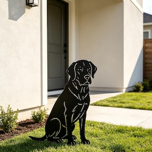 Può includere: Una sagoma piatta in metallo nero di un cane Labrador Retriever in posizione seduta. Il design presenta linee ritagliate per definire i tratti del viso, le orecchie e la struttura del corpo del cane, creando un solido ornamento da giardino.
