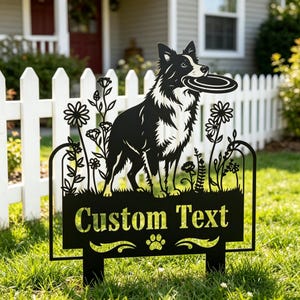 May include: Black metal yard sign featuring a Border Collie holding a frisbee. The sign includes a decorative floral design and the words "Custom Text" with a paw print. The sign is placed in a grassy yard with a white picket fence in the background.