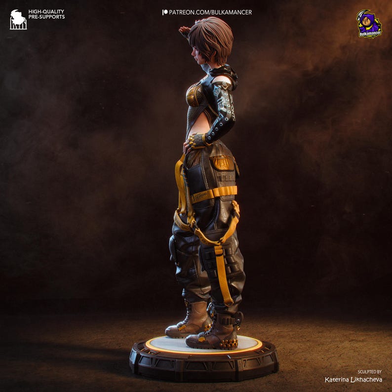 K&ouml;nnte beinhalten: Detaillierte Figur einer Person in futuristischer Kleidung mit einem Schwarz-Gold-Farbschema. Die Figur posiert mit erhobener Hand, tr&auml;gt ein Kapuzenshirt, Cargohose und Stiefel. Der Sockel ist eine kreisf&ouml;rmige Plattform.