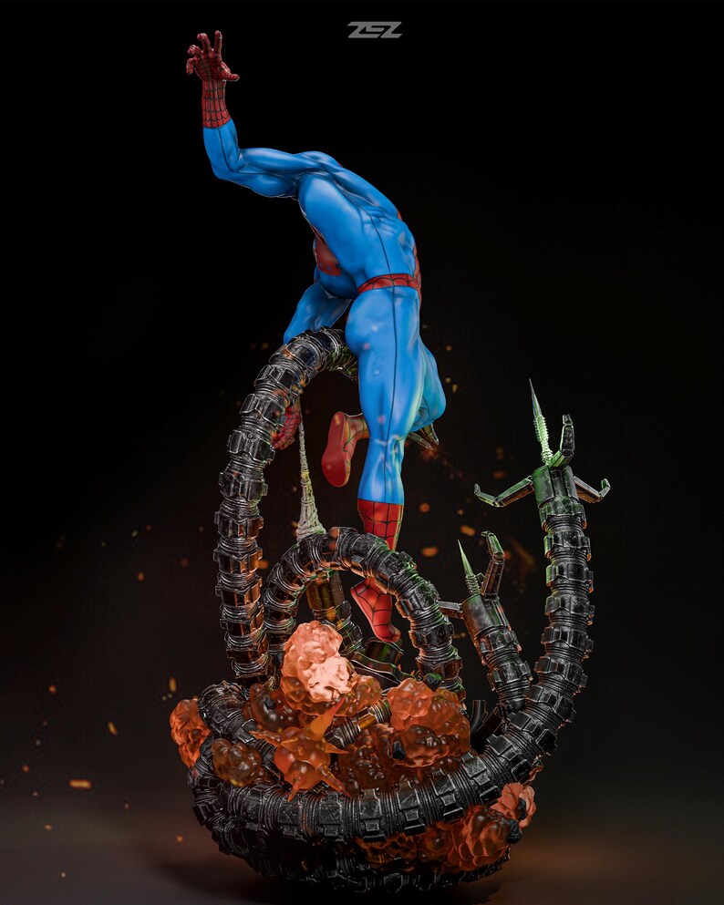 May include: A dynamic statue of Spider-Man in a classic blue and red suit, posed mid-action. He is entangled with mechanical tentacles, and the base features fiery orange and black elements. The statue has a detailed design and is set against a dark background.