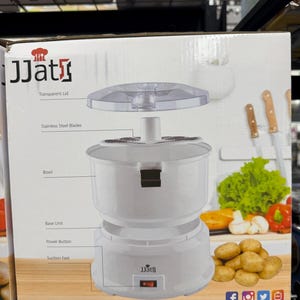 May include: A white JJat food processor with a transparent lid, stainless steel blades, and a bowl. The base unit has a power button and suction feet. The box also shows vegetables and knives.