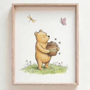 Puede incluir: Ilustración enmarcada de Winnie the Pooh sosteniendo un tarro de miel con la etiqueta "Hunny". La obra presenta un oso pardo claro de pie sobre hierba verde con abejas, una libélula y una mariposa rosa. El marco es de color marrón claro.