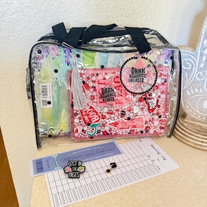 May include: A clear plastic bag containing a pink shaker-style pouch filled with beads and stickers labeled Dark Romance Reader. Includes a black beaded keychain with a pink tassel, a Morally Grey Book Club bookmark, a Lost In The Pages pin, and a reading log.