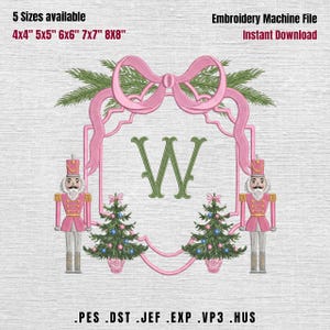 May include: An embroidery machine file design featuring a central green letter W framed by a pink ribbon border. Two pink nutcracker figures stand on either side, flanked by two small Christmas trees. Text includes 5 Sizes available 4x4 5x5 6x6 7x7 8x8, Embroidery Machine File, Instant Download, and file formats PES DST JEF EXP VP3 HUS.