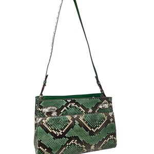 May include: A green and black snakeskin-effect shoulder bag with a long strap. The bag has a rectangular shape with a flap closure and silver-toned hardware. The interior lining is a solid green colour.