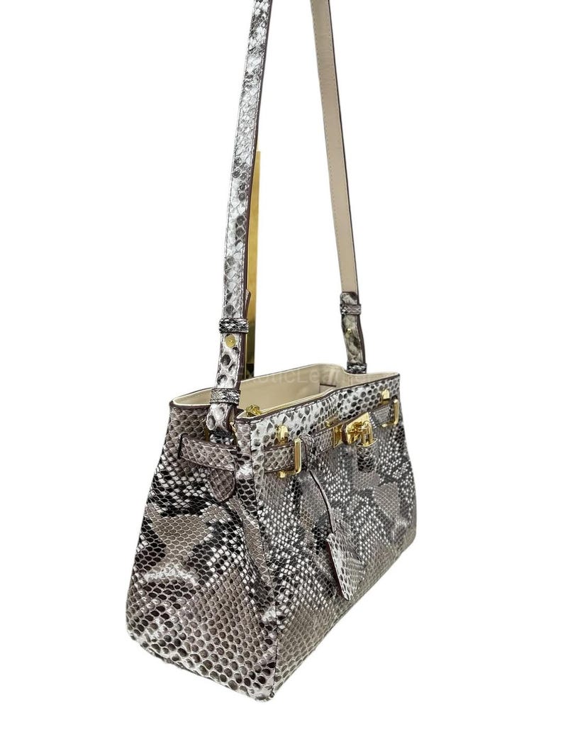 May include: A white ceramic mug with a black handle and the text "But First, Coffee" in a handwritten style. The mug is on a white surface. The mug is 10 cm tall.