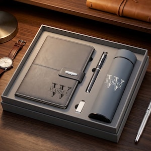 May include: A grey gift set in a box containing a notebook with a strap, a pen, a small rectangular USB drive, and a cylindrical bottle. The notebook and bottle are personalised with a large letter W and the name WARREN in black text.