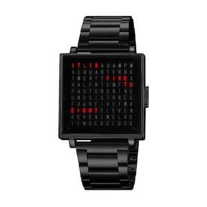 Pode incluir: Relógio de pulso preto com mostrador quadrado exibindo a hora em palavras. O mostrador do relógio tem texto vermelho iluminado em um fundo preto. A pulseira do relógio também é preta e de metal.
