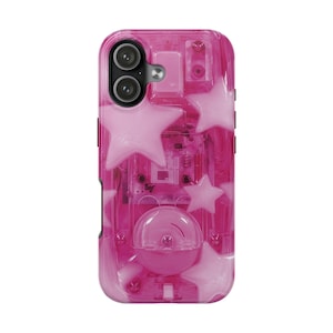 Puede incluir: Una funda de smartphone de color rosa intenso translúcido con un patrón de estrellas de color rosa claro opaco. El diseño revela componentes electrónicos internos, incluyendo una rejilla de altavoz circular y un módulo de cámara dual.