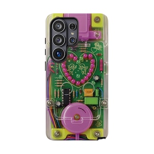 May include: A clear phone case featuring a green circuit board design with a central heart shape formed by pink beads. The design includes two small cherub illustrations, various electronic components like resistors and capacitors, and colorful wiring.