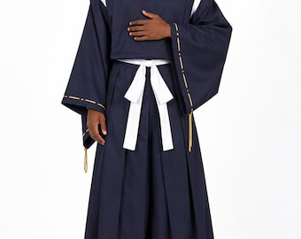 May include: A dark navy blue traditional-style outfit featuring a high-collar tunic with a gold circular emblem, wide sleeves with gold-stitched trim, and pleated hakama-style trousers secured with a white sash, paired with white socks and sandals.