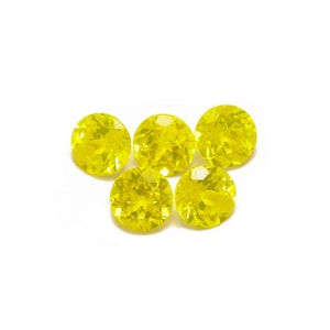 May include: Five round, bright yellow gemstones with faceted edges.