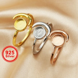May include: Three crescent moon rings with round, bezel-set, blank settings. The rings are gold, silver, and rose gold.