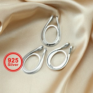 Könnte beinhalten: Drei silberne ovale Anhänger mit einem 925er Silber Stempel. Die Anhänger haben eine glatte, polierte Oberfläche.