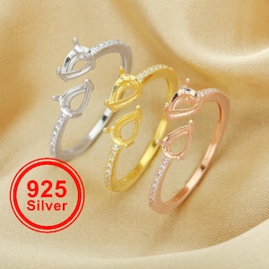 Puede incluir: Tres anillos con engastes en forma de pera, cada anillo es de un metal diferente: plata, oro y oro rosa. Cada anillo tiene una fila de pequeñas piedras transparentes alrededor de la banda.