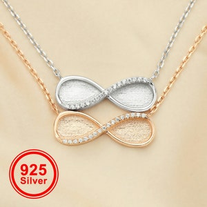 May include: Two infinity symbol necklaces, one silver and one rose gold, with small clear stones around the edges. The necklaces are layered on top of each other. The text "925 Silver" is in a red circle.