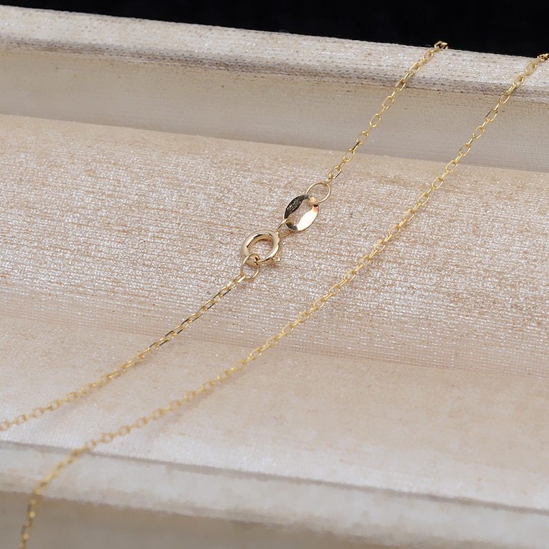 May include: A gold chain necklace with a lobster clasp closure. The chain is delicate and has a fine, linked design.