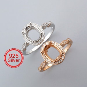 May include: Two silver rings with oval settings and a row of small clear stones around the settings. The ring on the left is silver, and the ring on the right is rose gold. The text "925 Silver" is in a red circle.