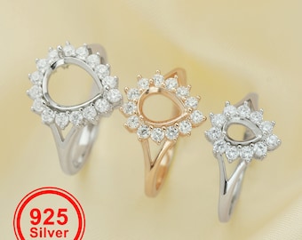 May include: Three silver rings with a teardrop-shaped setting for a stone. The rings are adorned with small, clear stones around the setting.