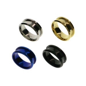 May include: Four different colored metal rings. The rings are silver, gold, blue, and black.