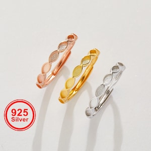 May include: Three delicate rings in rose gold, gold, and silver, each featuring a repeating pattern of elongated oval shapes. The rings are displayed on a white surface, with a red and white "925 Silver" logo in the lower left corner.