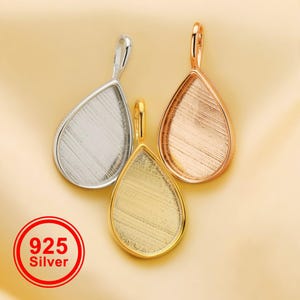 May include: Three teardrop-shaped pendant trays in silver, gold, and rose gold. Each has a loop at the top for a chain. The silver pendant has a 925 silver stamp in a red circle.