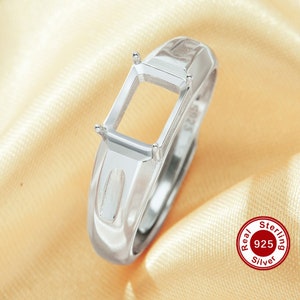 May include: A silver ring with a rectangular empty setting for a gemstone. The ring is made of sterling silver, as indicated by the "Real Sterling 925 Silver" stamp on the band.