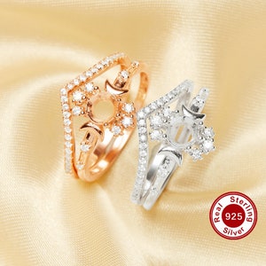 Op de afbeelding: Twee zilveren ringen met een maan- en zonontwerp. De ringen zijn bezet met heldere zirkonia-stenen. De ring aan de linkerkant is rosé verguld. De ring aan de rechterkant is van sterling zilver. De tekst "Real 925 Silver" is zichtbaar in de rechterbenedenhoek van de afbeelding.
