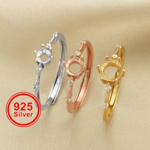 Könnte beinhalten: Drei Silberringe mit einer runden Zargenfassung und kleinen klaren Steinen. Die Ringe sind in verschiedenen Ausführungen: Silber, Roségold und Gold.