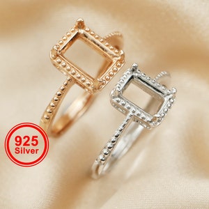 以下が含まれることがあります： 正方形のセッティングが施された銀のリング2つ。両方のリングはビーズ模様で飾られています。左側のリングはゴールドトーン。右側のリングはシルバートーン。925シルバー