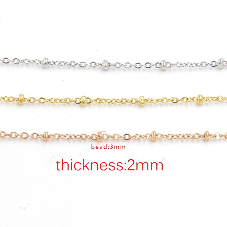 May include: Three strands of chain with small beads, one silver, one gold, and one rose gold. The chain is 2 mm thick and the beads are 3 mm in diameter. "bead:3mm" and "thickness:2mm" are written below the chains.