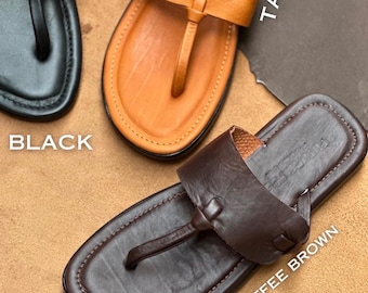 May include: Three thong-style sandals in black, tan, and coffee brown. Each sandal features a wide leather strap across the top, a toe post, and a flat sole. The text labels BLACK, TAN, and COFFEE BROWN are printed next to each respective sandal.