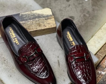 May include: A pair of deep burgundy loafers featuring a glossy crocodile-embossed leather texture on the vamp and a dark metallic horsebit detail. The interior insole is black with the gold text FUTURE FEET PREMIUM printed on the heel area.