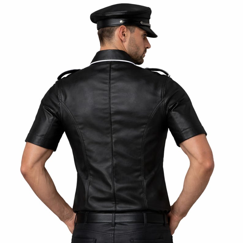 Pode incluir: Camisa preta de couro de manga curta com gola branca e ombreiras. A camisa &eacute; combinada com cal&ccedil;as de couro pretas e um bon&eacute; de couro preto a condizer. Um estilo cl&aacute;ssico e arrojado.