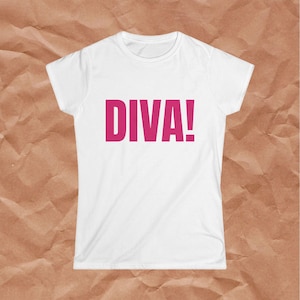 May include: A white short-sleeved t-shirt featuring the word DIVA! printed in bold, dark pink capital letters across the center of the chest. The garment has a classic crew neckline and a straight hemline, providing a clean and simple look.