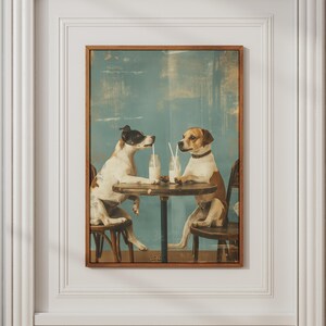 May include: A framed wall art print featuring two dogs sitting at a small round wooden table. One dog is white with black markings, and the other is brown and white. Each dog has a glass bottle with a straw in front of them on the table.