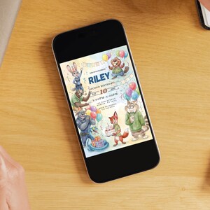 Pu&ograve; includere: Uno smartphone mostra un invito di compleanno colorato con personaggi di animali dei cartoni animati. L'invito include il nome "Riley", la data "10 maggio" e i dettagli dell'evento. Il telefono &egrave; appoggiato su una superficie di legno.